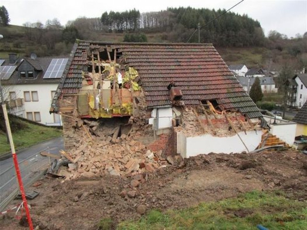 FOTO // Un bărbat şi-a dărâmat casa cu excavatorul, în timp ce chiriaşul era înăuntru